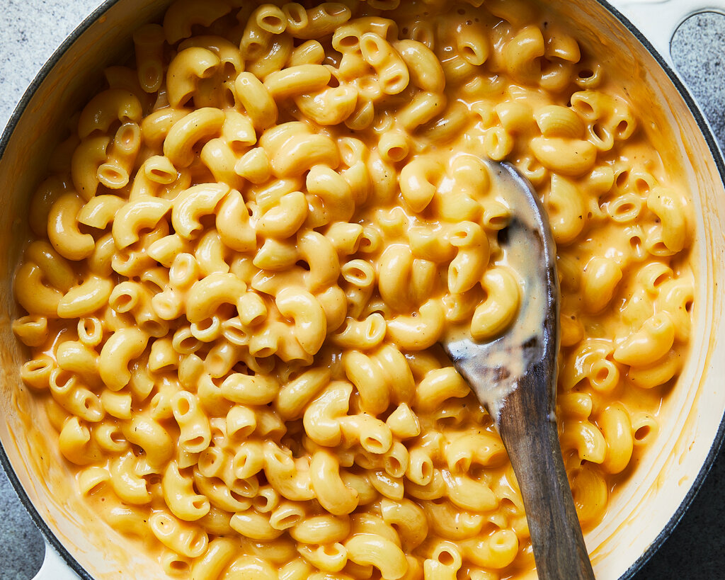 An overhead image of a Dutch oven filled with creamy mac and cheese.