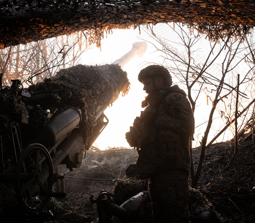 A soldier next to a missile launcher.