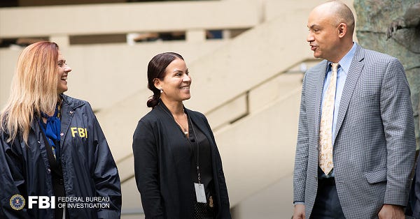 Three FBI special agents are shown conversing in the courtyard of FBI Headquarters in Washington, D.C.