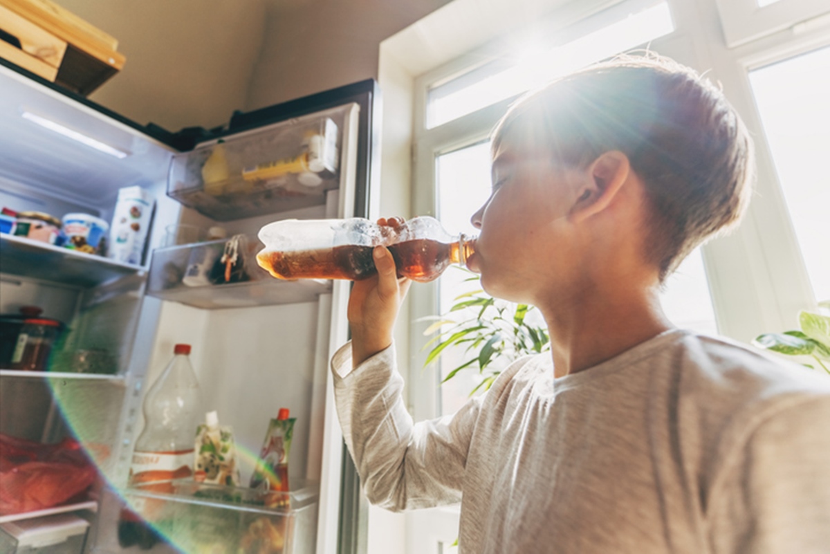 Criança bebendo refrigerante na garrafa - Metrópoles