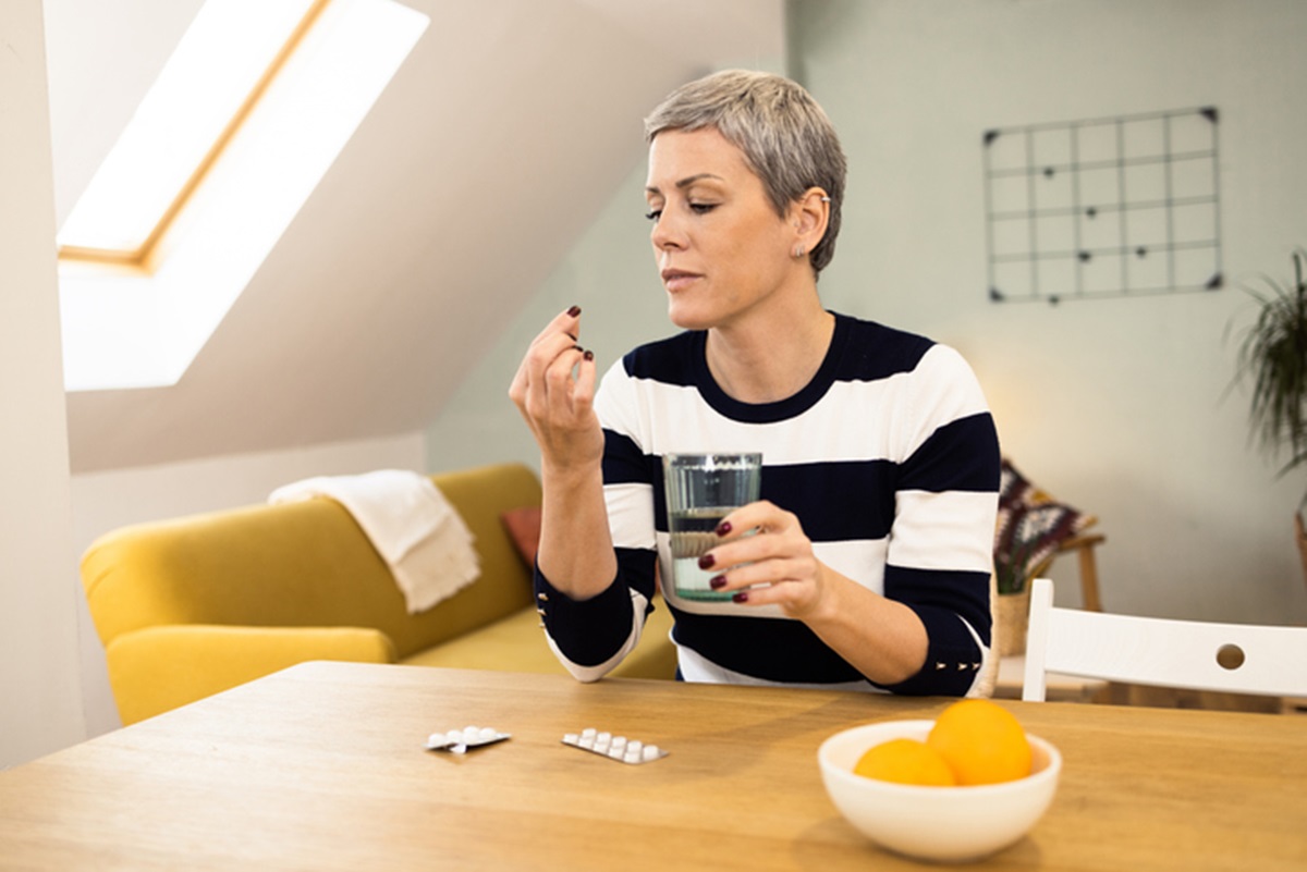 Mulher segurando comprimido - Metrópoles