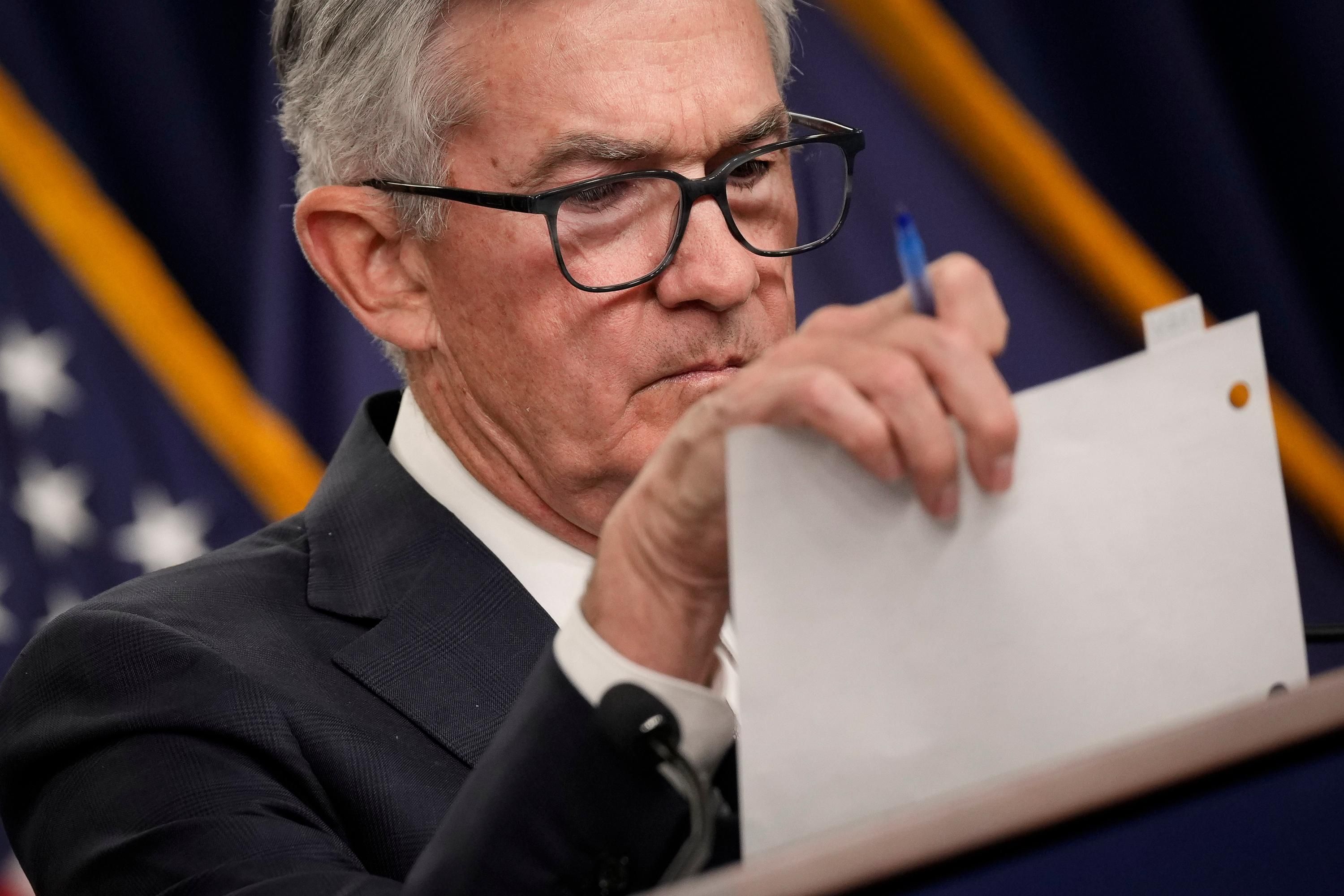 Fed Chair Jerome Powell looks at notes during a press conference