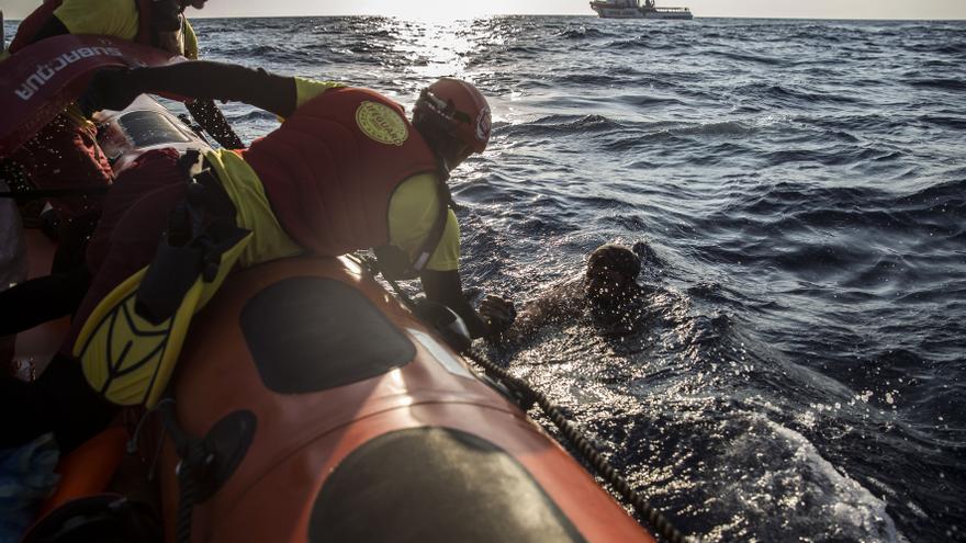 La tripulación del Open Arms saca del agua a uno de los ocupantes de una lancha que se negaban a ser trasladados a Túnez, que se hizo cargo de su rescate este domingo.
