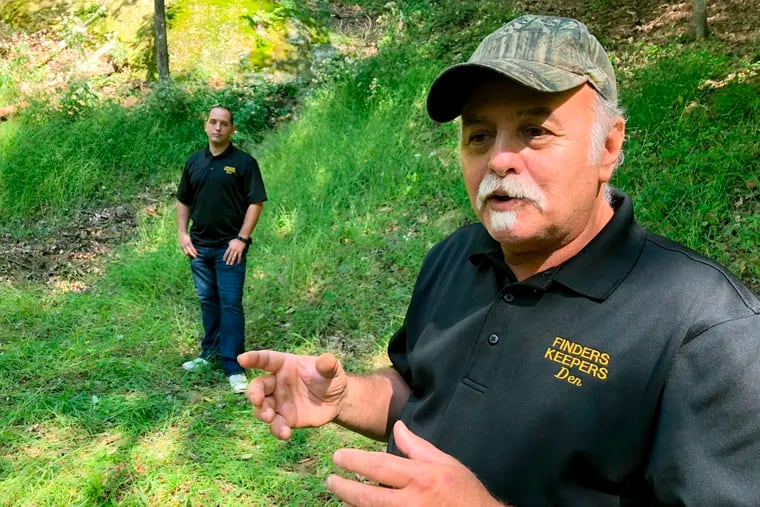 In this Sept. 20, 2018 photo, Dennis Parada, right, and his son Kem Parada stand at the site of the FBI's dig for Civil War-era gold in Dents Run, Pennsylvania. The FBI says the excavation came up empty, but the Paradas believe investigators might have found the legendary gold cache. (AP Photo/Michael Rubinkam)'s dig for Civil War-era gold in Dents Run, Pennsylvania. The FBI says the excavation came up empty, but the Paradas believe investigators might have found the legendary gold cache. (AP Photo/Michael Rubinkam)