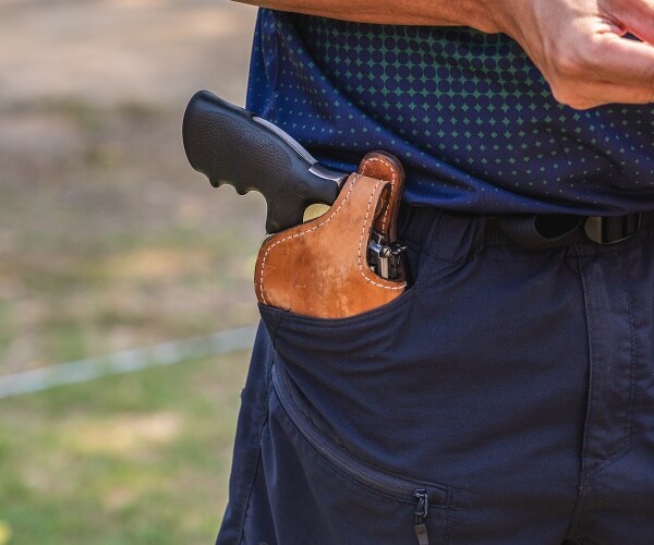 handgun in holster in mans pocket