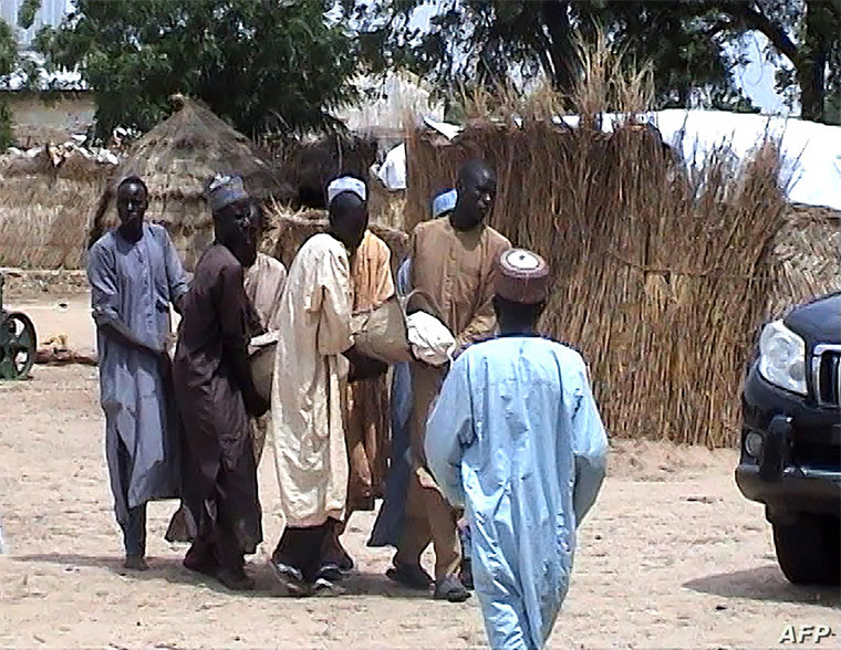 en carry a victim after an attack by Boko Haram militants on a funeral in Budu, near Maiduguri, northeast Nigeria
