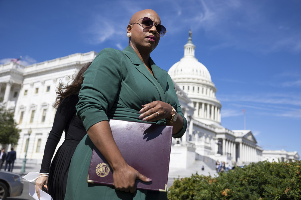 Rep. Ayanna Pressley walks with folder under her arm outside U.S. Capitol.