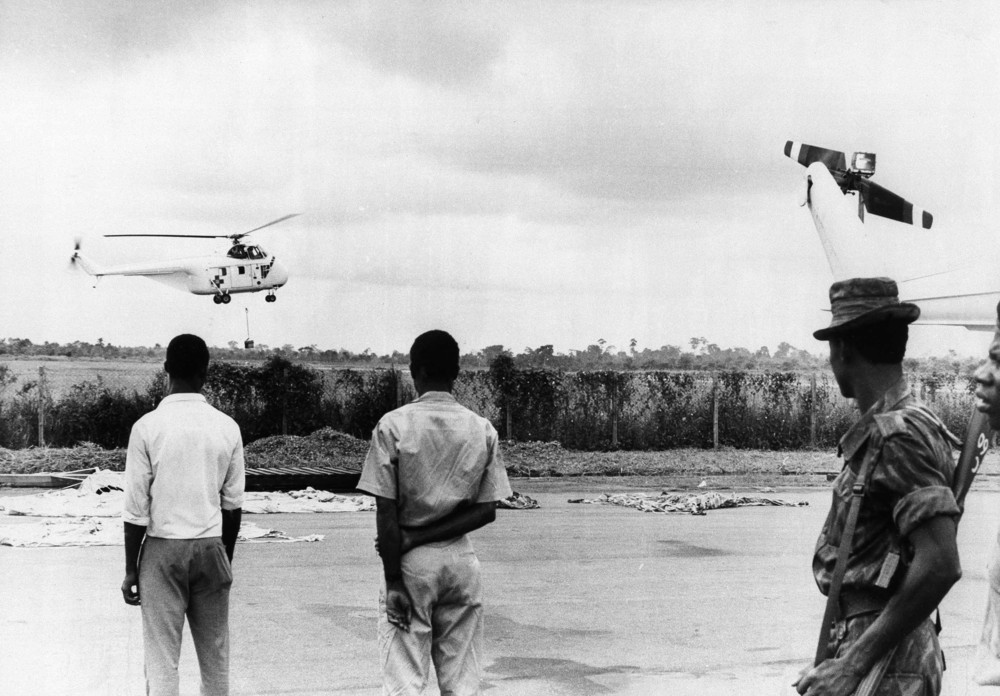 On this date in 1968: A UNICEF helicopter is pictured practicing a food lift at Lagos Airport, Nigeria.  A group of Americans, some with experience in the Vietnam War, piloted helicopters for UNICEF, dropping food supplies to aid starving Biafrans in Nigeria in the midst of a civil war that saw the Nigerian government fight with the Republic of Biafra, a secessionist state. Televised images of malnourished Biafran children saturated Western media and increased
 humanitarian aid from NGOs to the region.