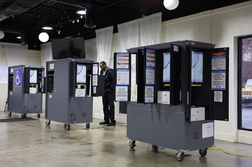 A voter casts his ballot at a polling station for the U.S. Senate runoff election today in Atlanta, Georgia.