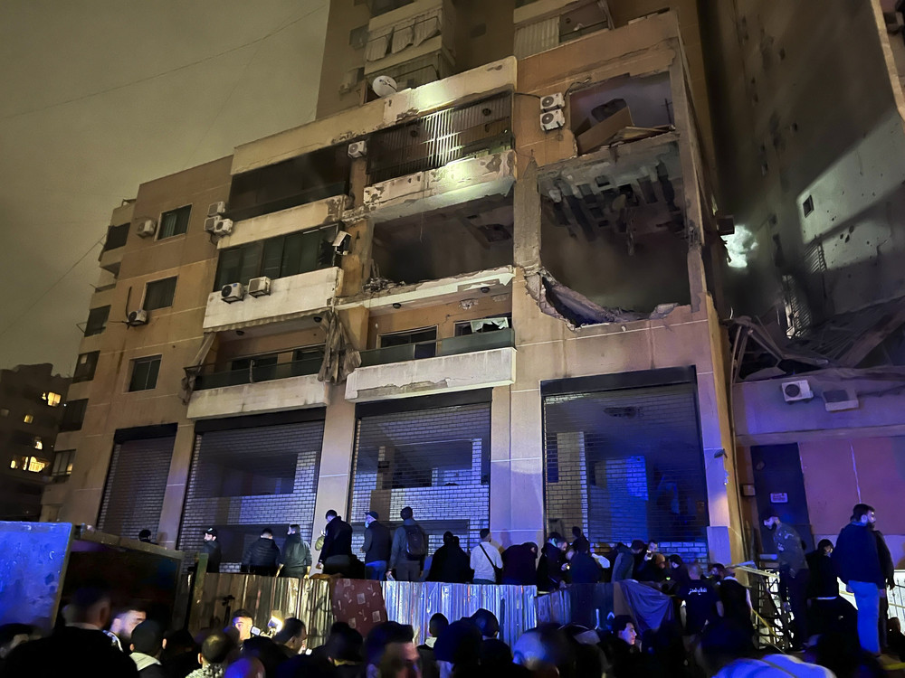 People stand outside a building after an explosion in southern Beirut, Lebanon.