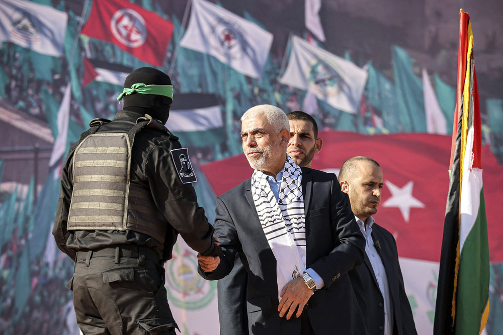 Yahia al-Sinwar (center), Gaza Strip chief of the Palestinian Islamist Hamas movement, shakes hands with a masked fighter of Hamas' Qassam Brigades in Gaza City on Dec. 14, 2022. 
