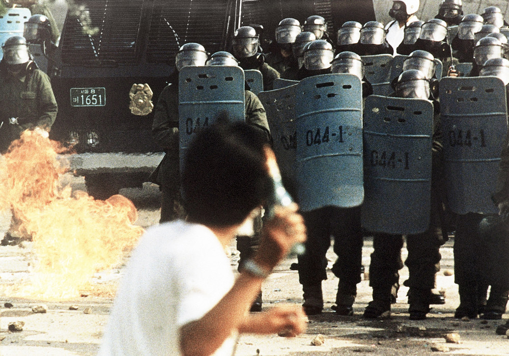 On this date in 1987: A South Korean student throws a gasoline bottle bomb at shielded and helmeted ranks of riot police in Seoul during a violent clash at Yonsei University, one of Seoul's leading schools. The violence occurred as thousands of students staged pro-democracy demonstrations in the capital and provincial cities, and forced the ruling government to hold elections that established South Korea's Sixth Republic, the present day governmental system of the
 country. 