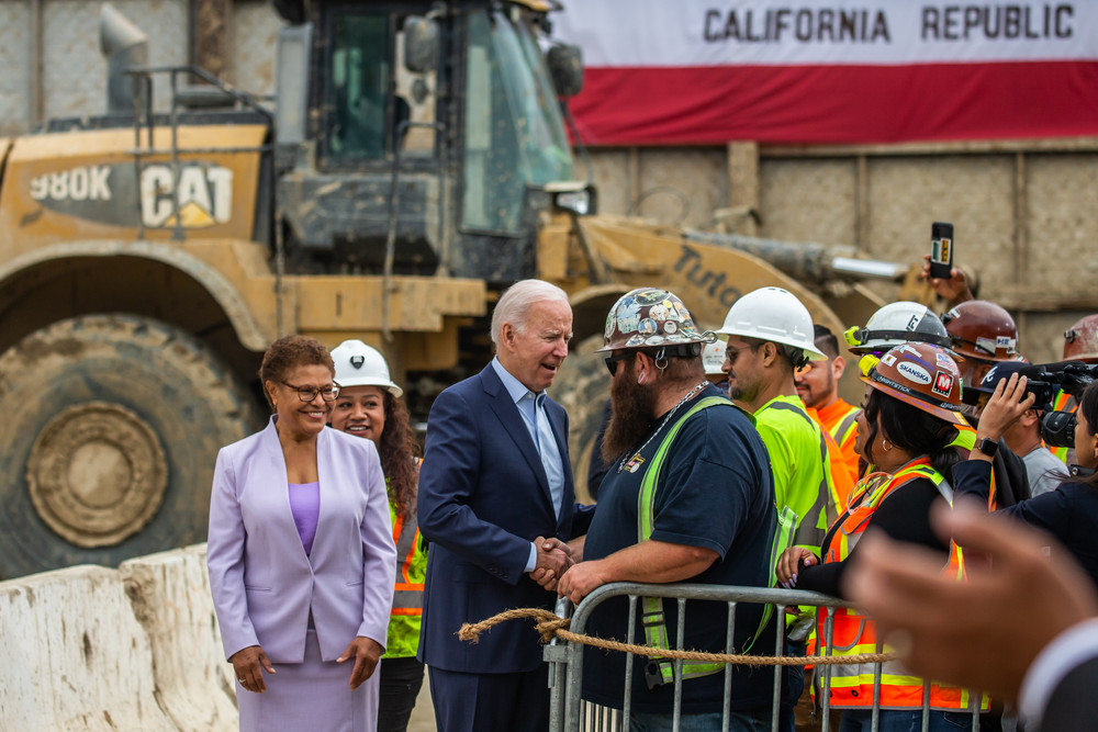 President Joe Biden and then-Rep. Karen Bass (D-Calif.) speak with workers at the Metro D Line Extension Transit Project in Los Angeles.