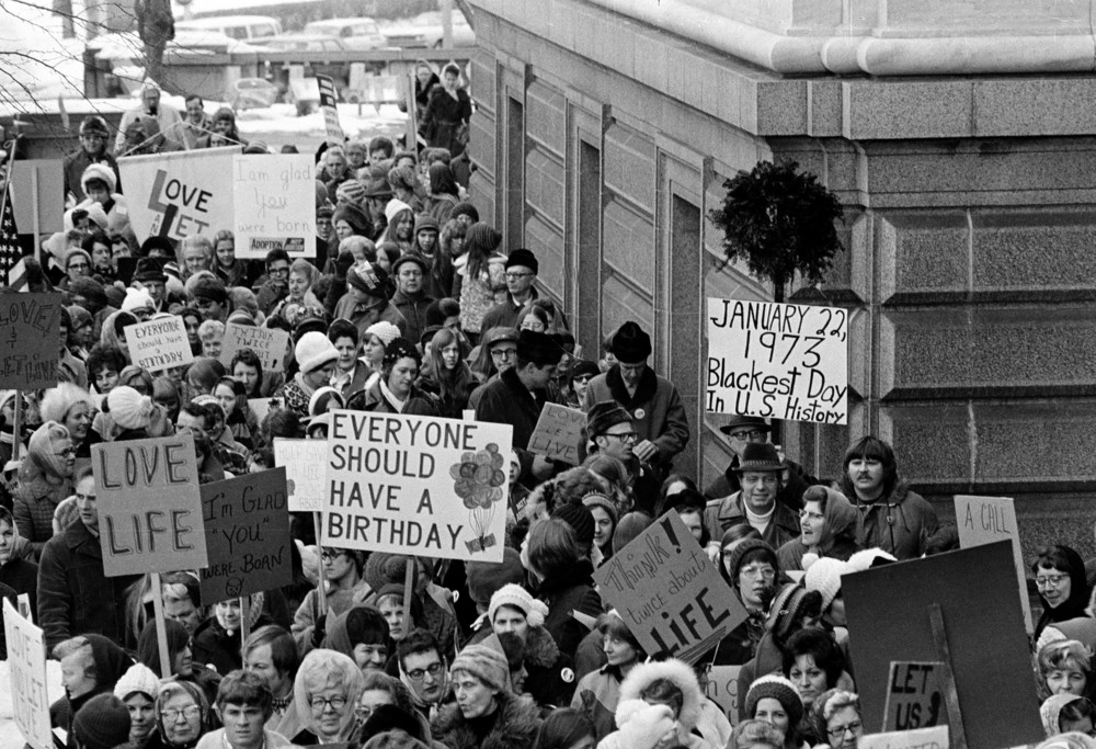 On this date in 1973: The U.S. Supreme Court decides Roe v. Wade. Pictured are an estimated 5,000 people marching around the Minnesota Capitol building in St. Paul protesting the decision, which ruled against state laws that criminalize abortion. 