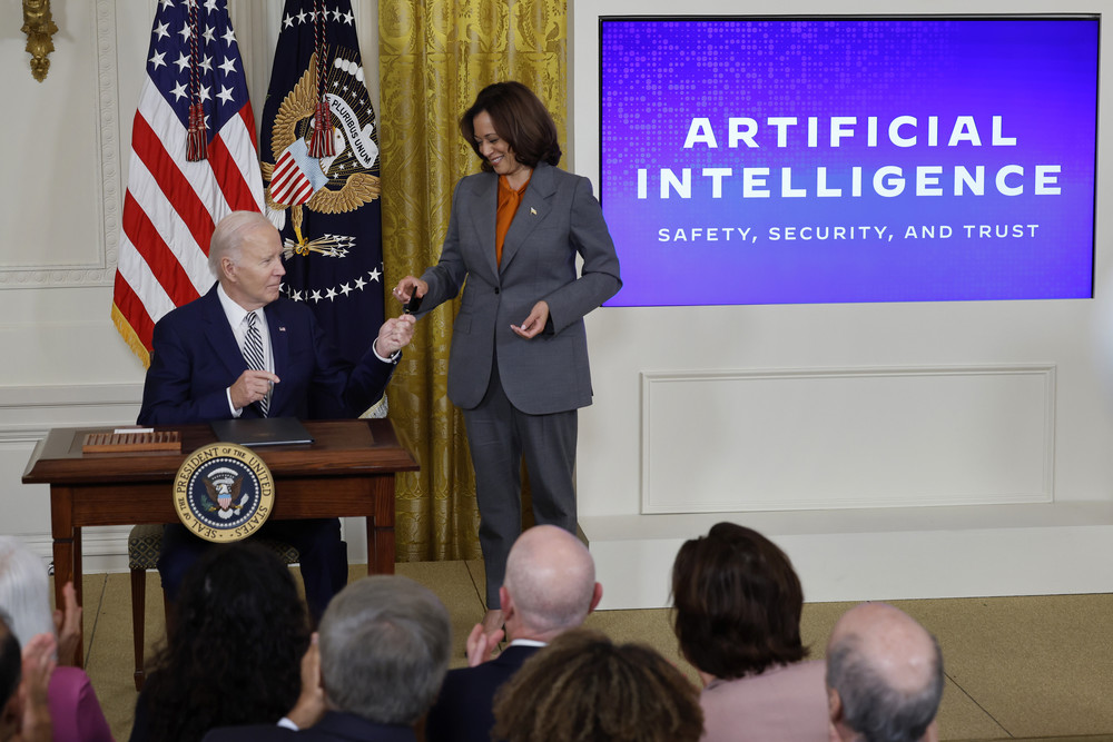 President Joe Biden hands Vice President Kamala Harris the pen he used to sign a new executive order regarding artificial intelligence.