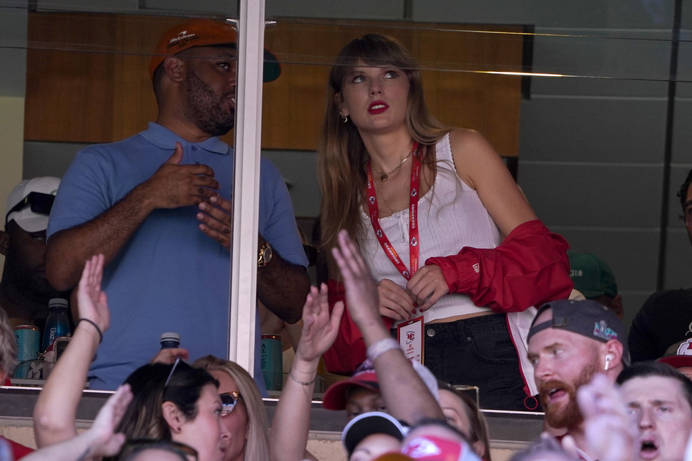 Taylor Swift watches from a suite inside Arrowhead Stadium during the first half of an NFL football game between the Chicago Bears and Kansas City Chiefs.