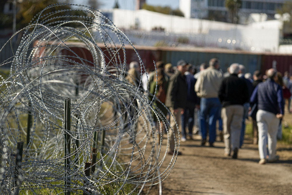 Concertina wire lines the path as members of Congress tour an area near the Texas-Mexico border in Eagle Pass, Texas.