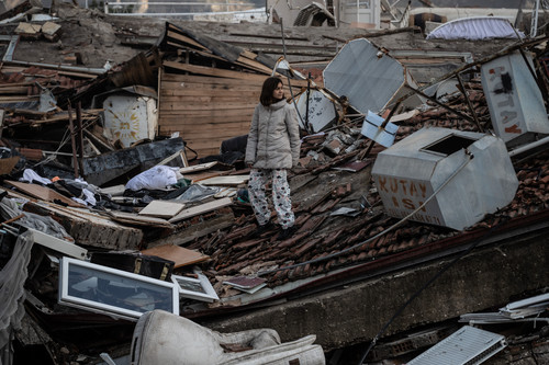 A girl searches a collapsed building in Hatay, Turkey, after a 7.8-magnitude earthquake, followed by a 7.5-magnitude tremor, hit the region.