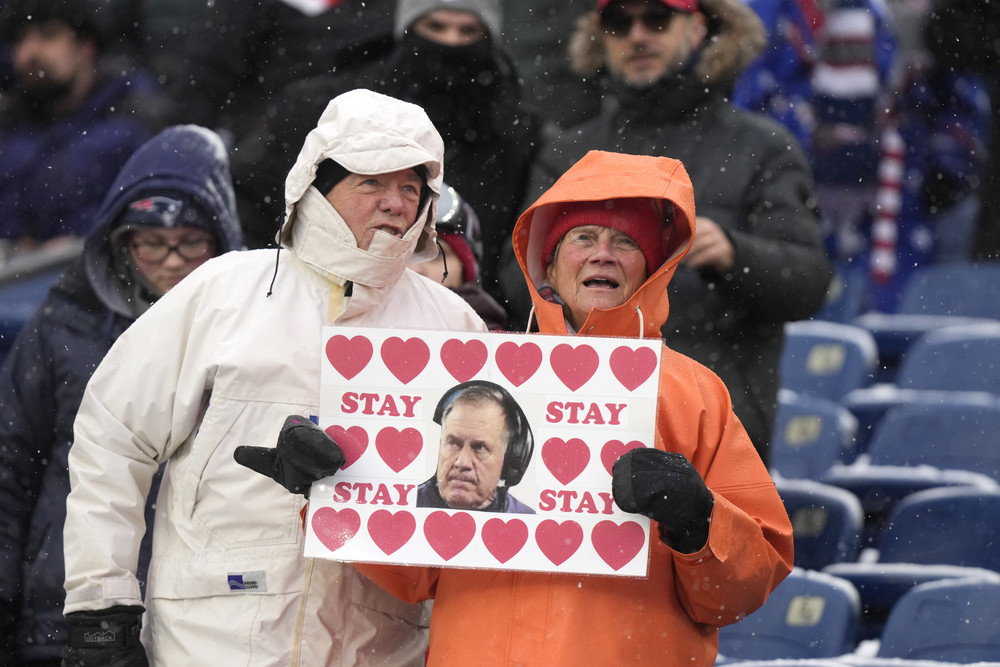 A fan displays a placard with a likeness of New England Patriots head coach Bill Belichick prior to an NFL football game against the New York Jets, Sunday, Jan. 7, 2024, in Foxborough, Mass. (AP Photo/Steven Senne)