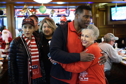 Georgia Republican Senate nominee Herschel Walker greets supporters as his wife Julie Blanchard looks on during a campaign stop in Marietta, Georgia.