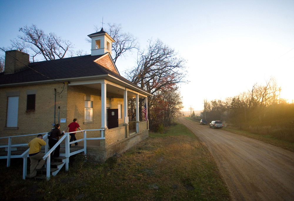 People enter the town hall just after sunrise to cast their ballots in the rural township of San Francisco, Minn. in 2008. The town hall, which is a converted one room school house, serves as the polling location for the township. 