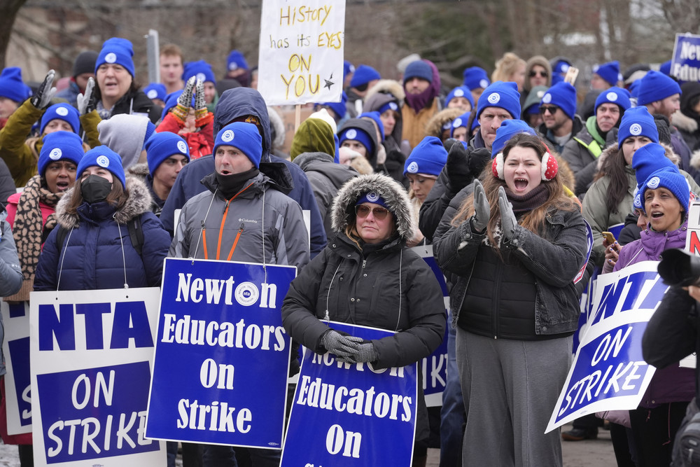 FILE - Striking Newton teachers and supporters display placards and chant during a rally, Tuesday, Jan. 30, 2024, outside Newton City Hall, in Newton, Mass. An 11-day teachers strike in the Boston suburb ended late Friday, Feb. 2, after both sides tentatively agreed on a new contract. (AP Photo/Steven Senne, File)