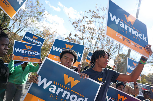 Supporters of Sen. Raphael Warnock hold campaign signs during a rally in Atlanta, Georgia.