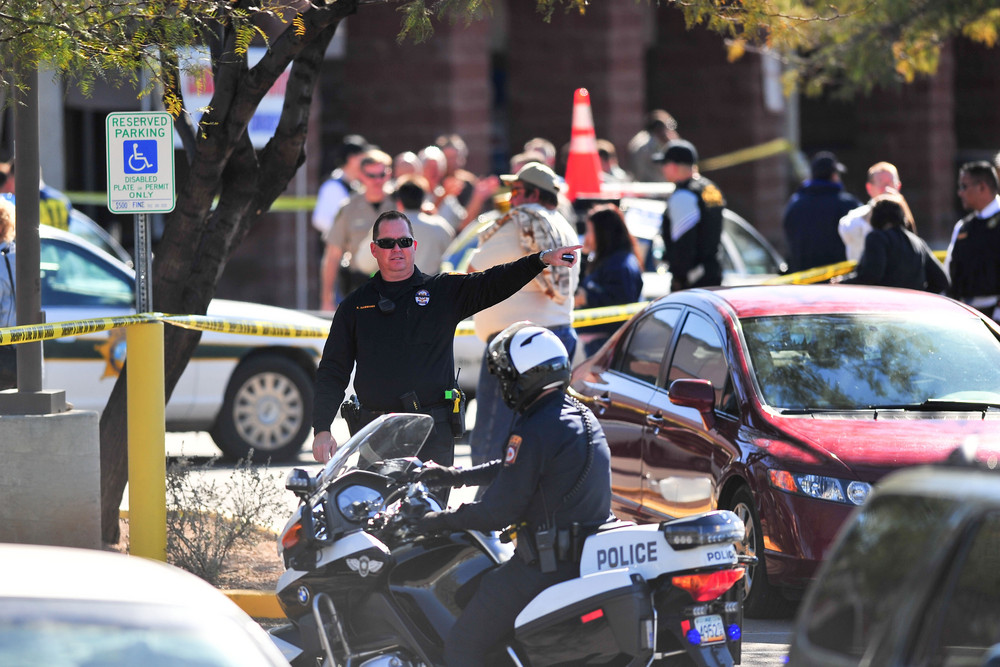 On this date in 2011: Emergency workers gather at the scene of a shooting involving Rep. Gabrielle Giffords (D-Ariz.). Giffords and 18 others were shot during a meeting with constituents outside a Safeway grocery store in Tucson, Ariz. Six people were killed, including federal District Court Chief Judge John Roll, one of Giffords' staffers and a nine-year-old girl.