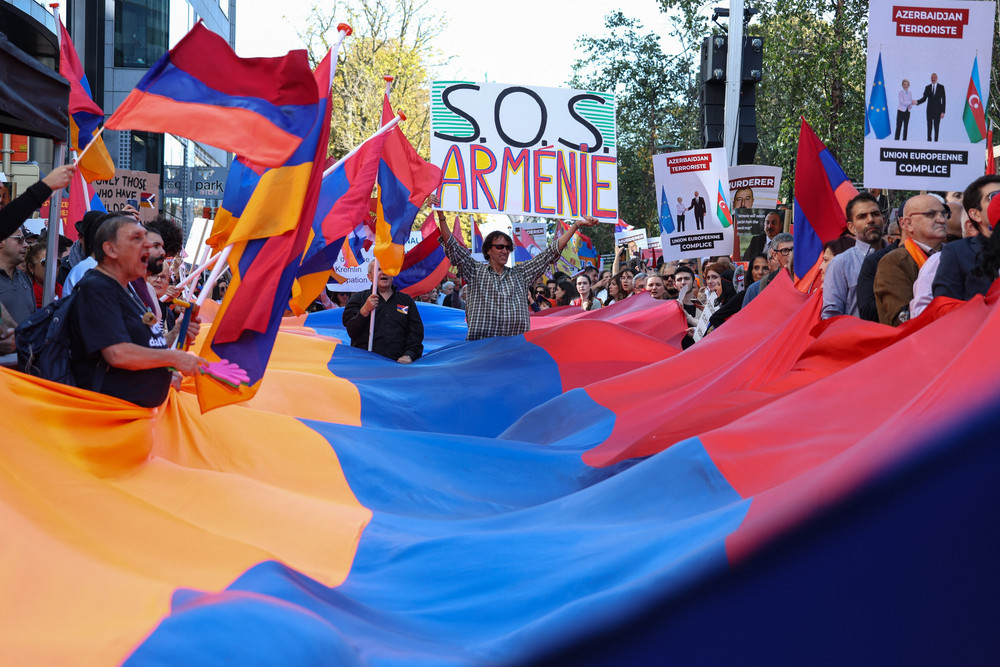 Protestors carry placards and wave Armenian flags during a demonstration in support of Armenians in Brussels on Oct. 1, 2023. 