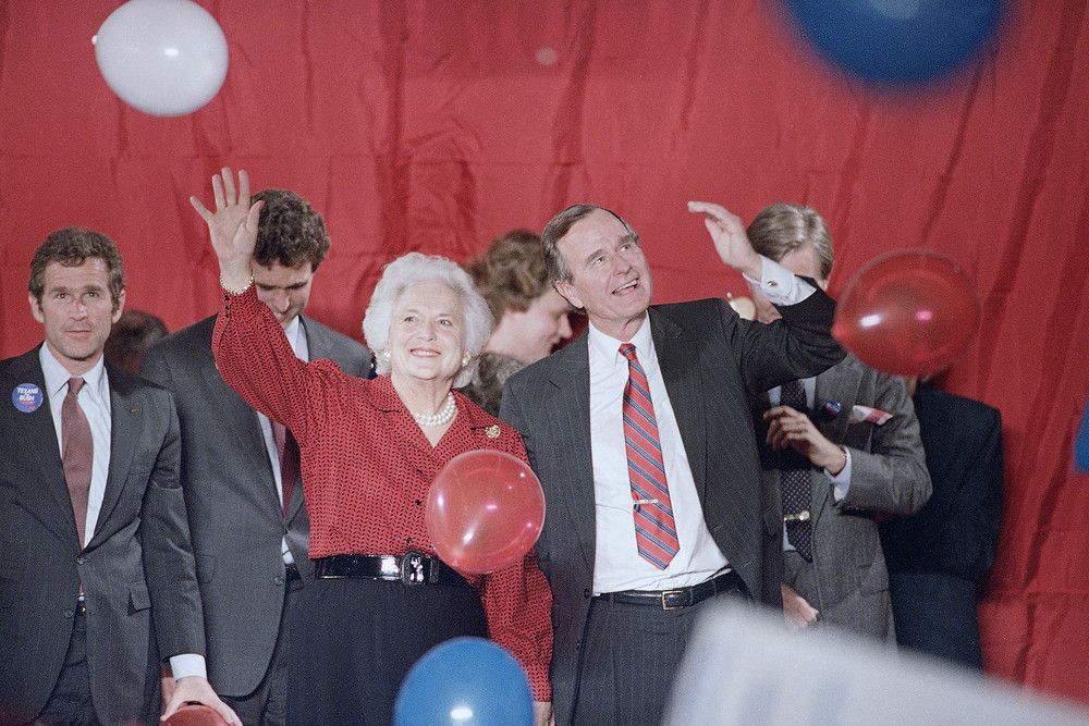 On this date in 1988: Then-Vice President and presidential candidate George H.W. Bush and Barbara Bush wave as balloons are dropped during a welcome rally as they watch the 1988 presidential election returns in Houston; at left is George W. Bush. Bush won with 426 electoral votes to his opponent Massachusetts Gov. Michael Dukakis' 111. 