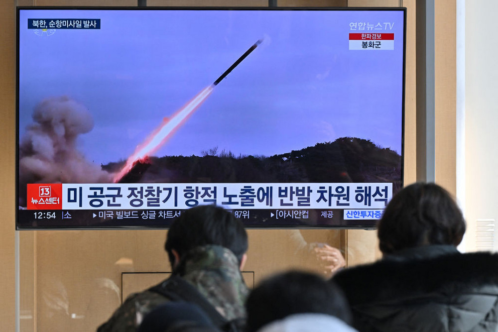 People watch a television screen showing a news broadcast with file footage of a North Korean missile test at a railway station in Seoul.