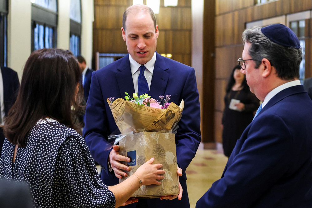 Britain's Prince William receives a bouquet of flowers for his wife Kate during a visit to the Western Marble Arch Synagogue on Feb. 29, 2024 in London.