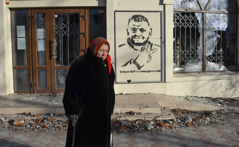 An elderly woman walks along a street against a background of graffiti depicting General Valery Zaluzhny, head of Ukraine's armed forces, in Bakhmut, Ukraine.