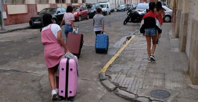 Varias de las menores marroques devueltas de Palencia a Melilla cargan con sus maletas en la ciudad autnoma.- JOS PALAZN/PRODEIN