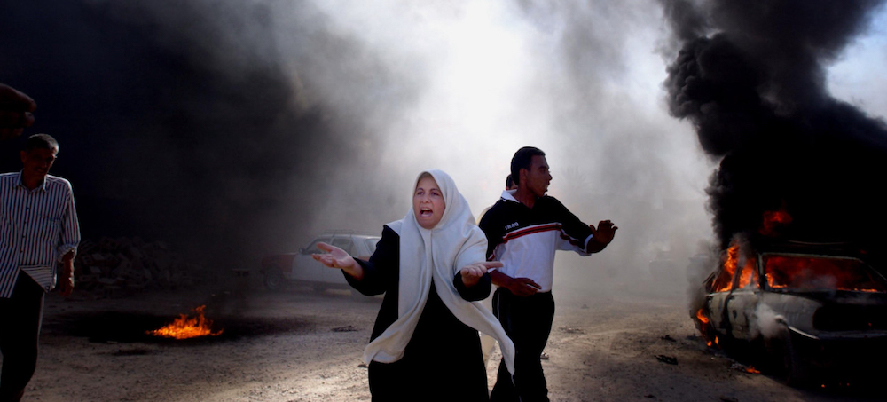 A desperate mother searches for her two children after they disappeared amid a gigantic fire at an illegal petrol station in central Baghdad. The Iraq war began in March 2003 with a U.S.-led invasion which ended nearly 25 years of Ba'athist rule. (photo: Moises Saman/Magnum Photos)