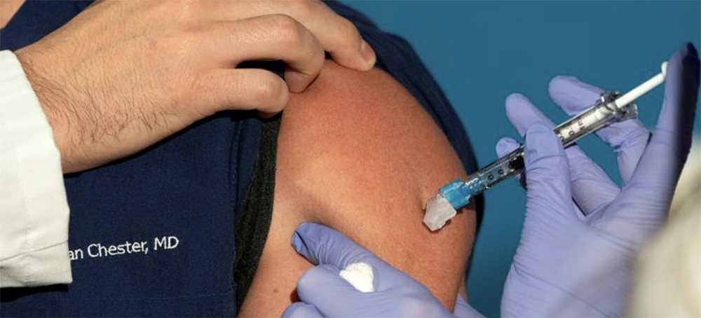 Nurse Lillian Wirpsza, right, administers a COVID-19 vaccine to emergency department Dr. Sean Chester, at George Washington University Hospital in Washington, D.C. December 14, 2020. (photo: Jacquelyn Martin/Reuters)