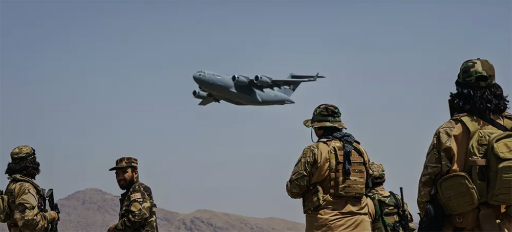 A C-17 Globemaster takes off as Taliban fighters secure the outer perimeter of the Hamid Karzai International Airport in Kabul, Afghanistan on August 29, 2021. (photo: Marcus Yam/Los Angeles Times)