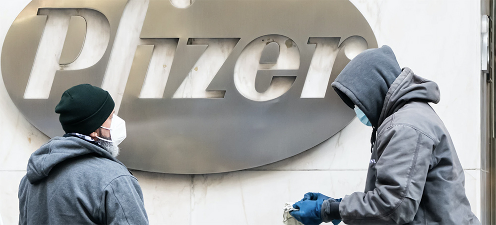 Workers clean the Pfizer logo on Dec. 21, 2020, in New York. (photo: Noam Galai/Getty Images)