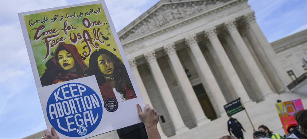 Participants hold signs at the U.S. Supreme Court on Dec. 1 in Washington, D.C. (photo: Leigh Vogel/Getty Images)