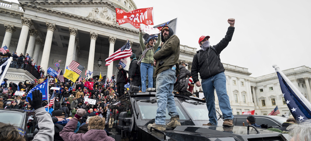 Trump supporters stand on a Capitol Police armored vehicle as others take over the steps of the Capitol on Jan. 6, 2021. (photo: Bill Clark/CQ-Roll Call/Getty Images)