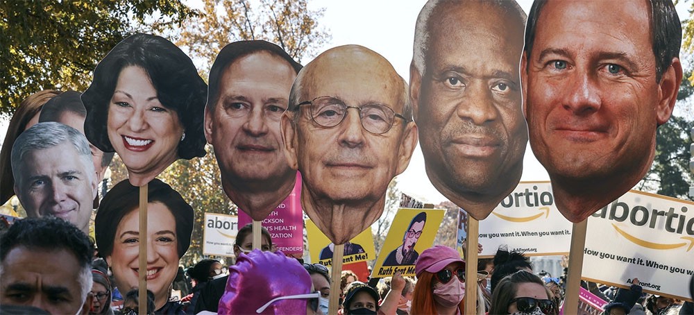 Demonstrators rally carrying images of Supreme Court justices. (photo: Getty Images)