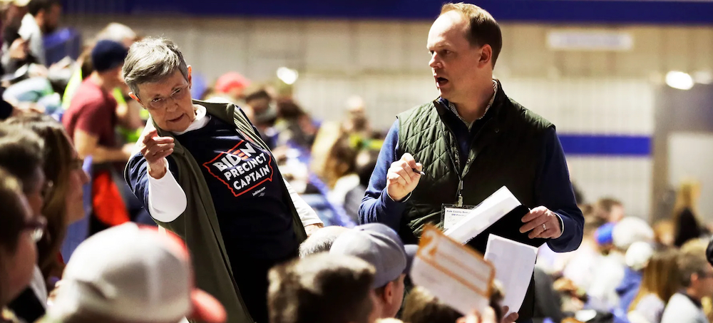 Precinct 68 Iowa caucus voters seated in the Joe Biden section hold up their first votes as they are counted at the Knapp Center on the Drake University campus in Des Moines, Iowa. (photo: Gene J. Puskar/AP)