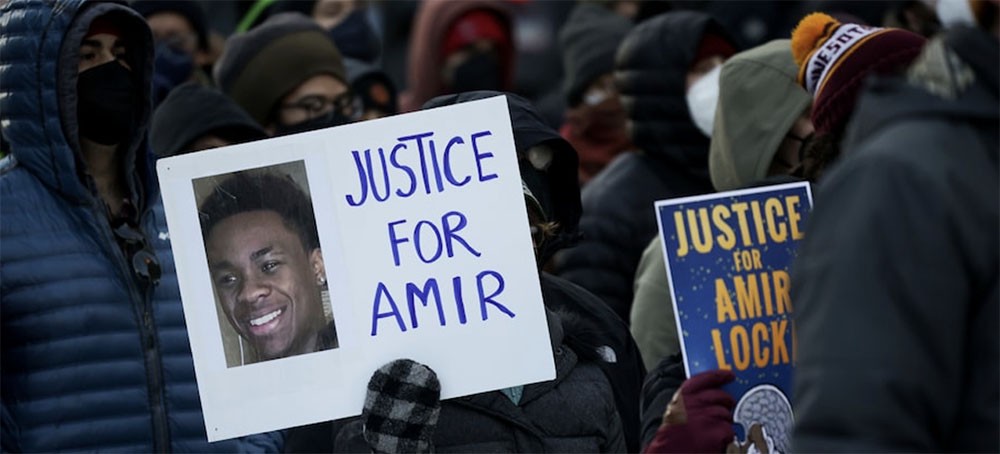 A protester holds a sign demanding justice for Amir Locke at a rally in Minneapolis on Feb. 5. (photo: Christian Monterrosa/AP)