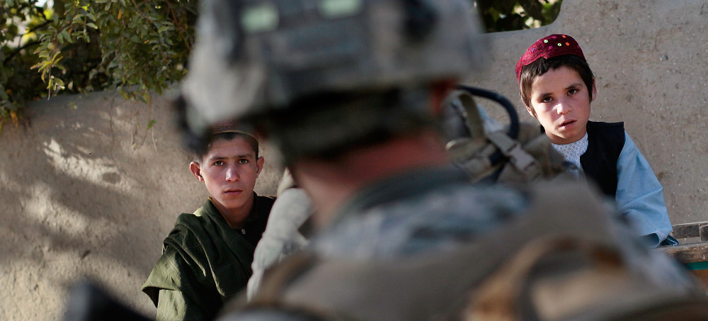 Afghan Pashtun children watch a soldier in the 1st Battalion, 2nd Brigade of the 101st Airborne Division during a patrol near Zoldag Mongah west of Kandahar, Afghanistan, on Oct. 8, 2010. (photo: Chris Hondros/Getty)