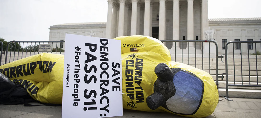 A blow-up figure lies on the ground as the Declaration for American Democracy coalition hosts a rally calling on the Senate to pass the For the People Act, outside the Supreme Court in Washington on Wednesday, June 9, 2021. (photo: Caroline Brehman/CQ-Roll Call/Getty Images)