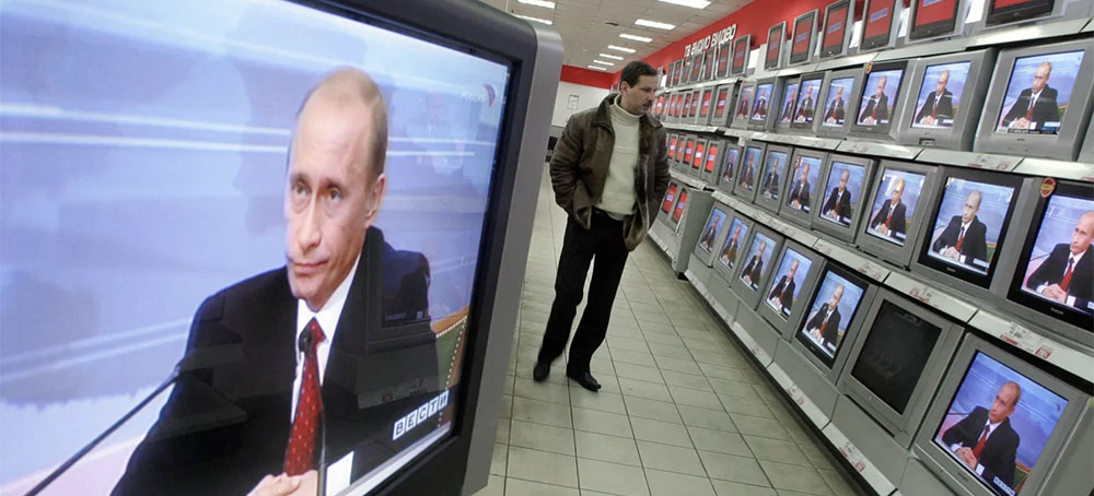 A man looks at TV sets broadcasting Russian president Vladimir Putin's annual press conference in Moscow in 2006. (photo: AFP/Getty Images)