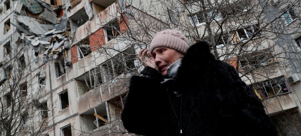 A woman reacts while speaking near a block of flats, which was destroyed during Ukraine-Russia conflict in the besieged southern port city of Mariupol, Ukraine. (photo: Alexander Ermochenko/Reuters)