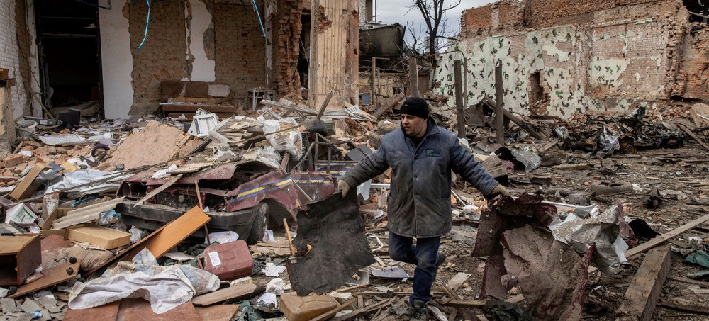  A volunteer clears up rubble after a Russian attack in Kharkiv. If Russia is not paid for oil and gas, it will reduce the number of missiles hurtling towards Ukraine. (Photo: Chris McGrath/Getty)