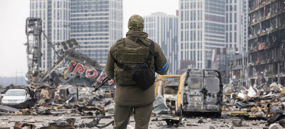 A soldier stands in front of the ruins of Kyiv's Retroville shopping center, which was destroyed in a Russian shelling attack. At least six people died during the incident. (photo: Mykhaylo Palinchak/SOPA/Getty Images)