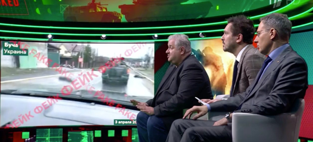 A screenshot from a discussion of the Bucha massacre on the Russian state television show 'Antifake,' in which the killings were described as a hoax and genuine images of the victims were stamped 'Fake' in Russian and English as they played in the background. (photo: Channel One Russia)